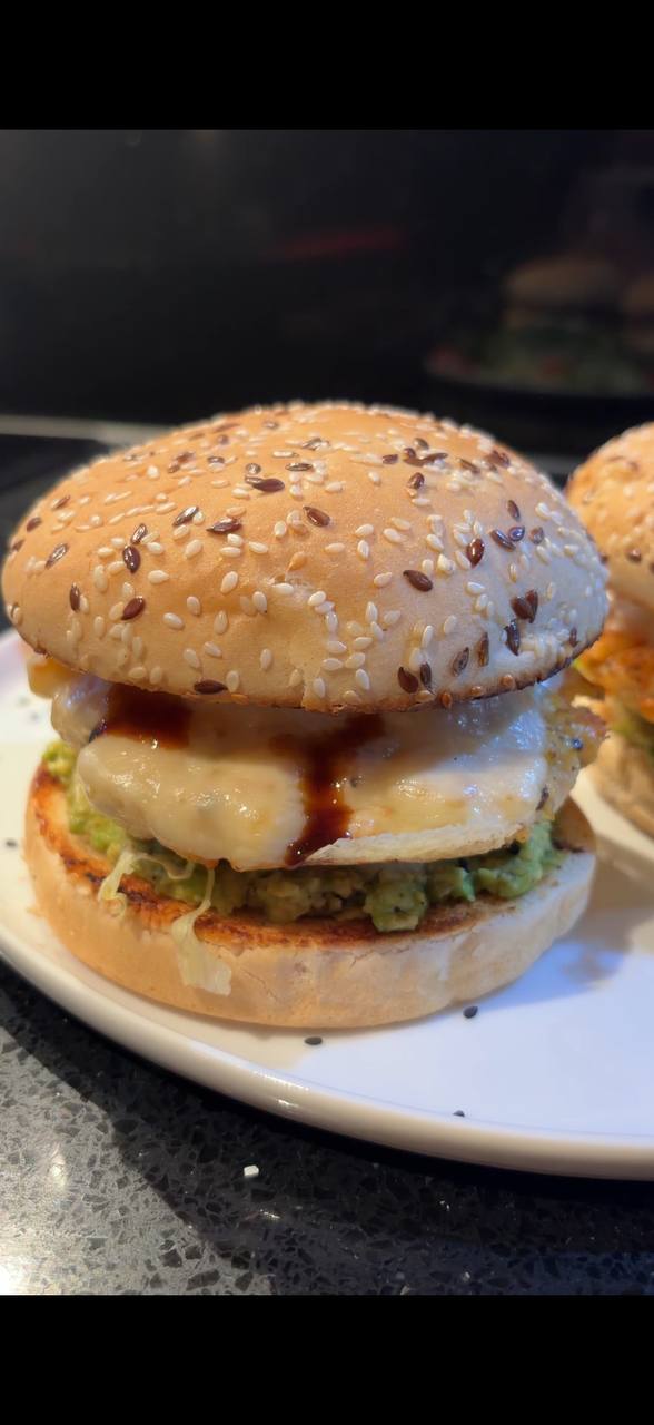 Shrimp burger close up with sesame bun melted cheese and teriyaki sauce
